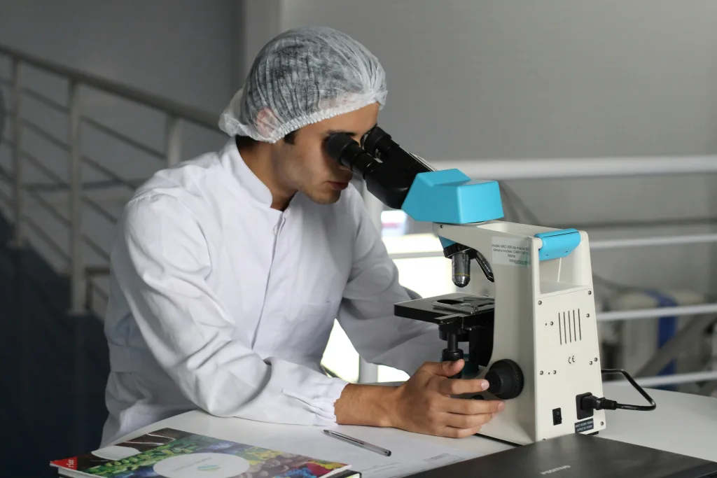 Wissenschaftler im Laborkittel am Mikroskop