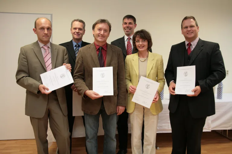 Gruppe des ersten Jahrgangs hält die Abschlussurkunden in den Händen